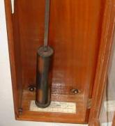 internal view of the Gent clock showing the pendulum bob and useless swing scale