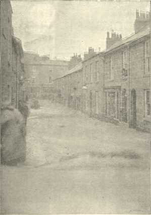 Torrents of water flooding down the street - small boat in the distance