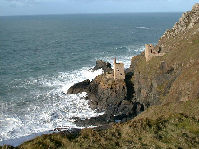 Two ruined engine houses perched precariously part way down the cliff side