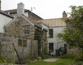 A small stone building with a white chimney